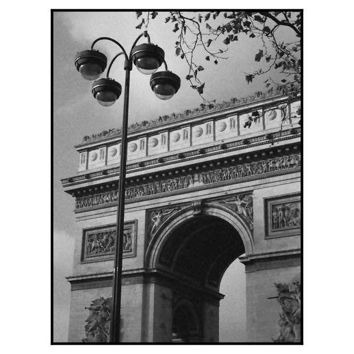 A street lamp stands in front of the Arc de Triomphe in Paris.