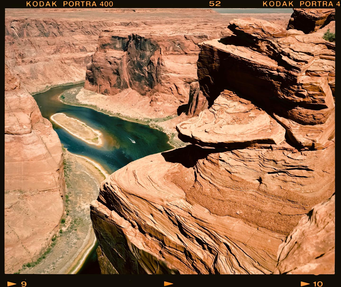 A river winds through a deep canyon with steep, rocky walls under a clear sky.