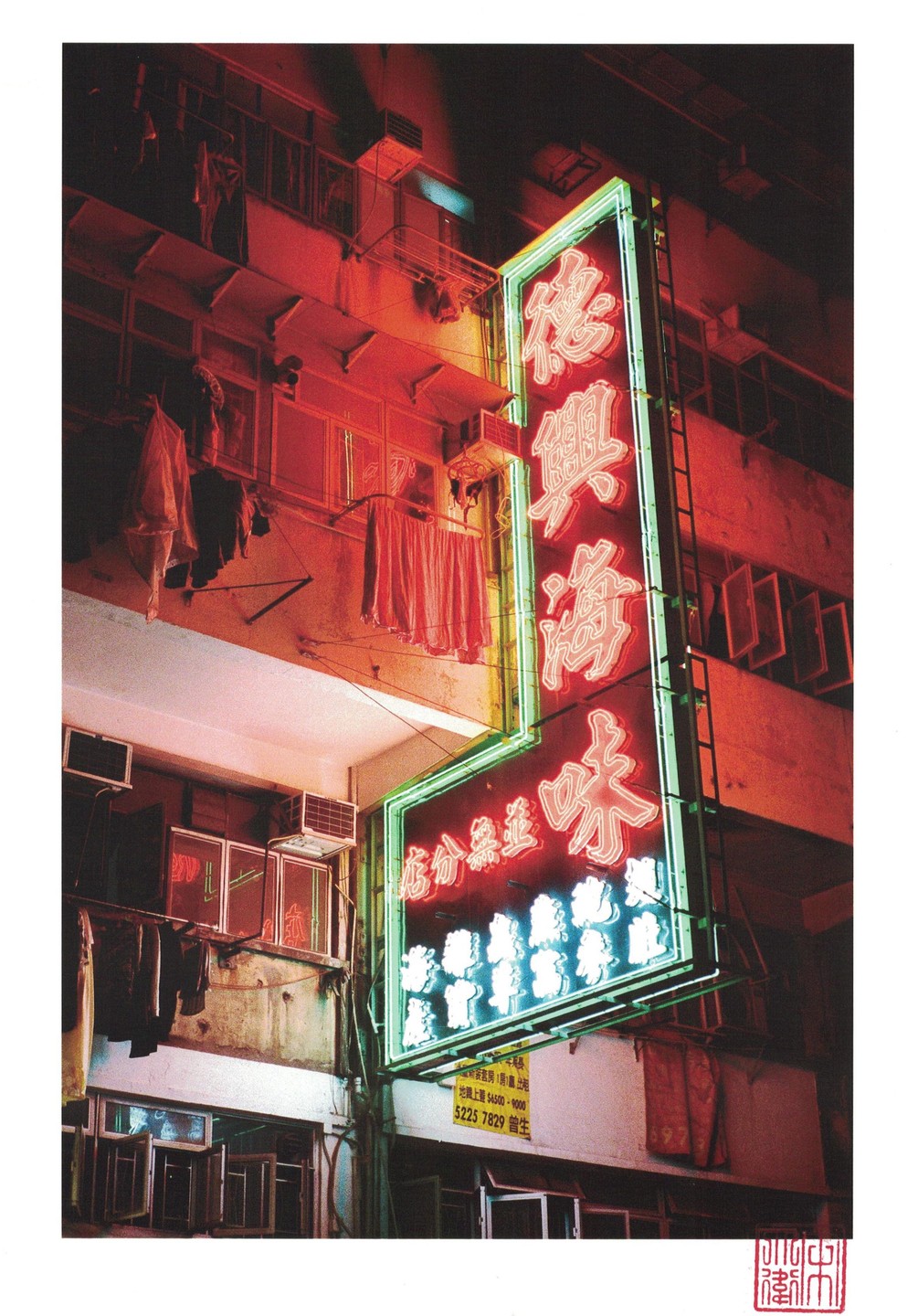 A large neon sign with Chinese characters illuminates a building facade at night.