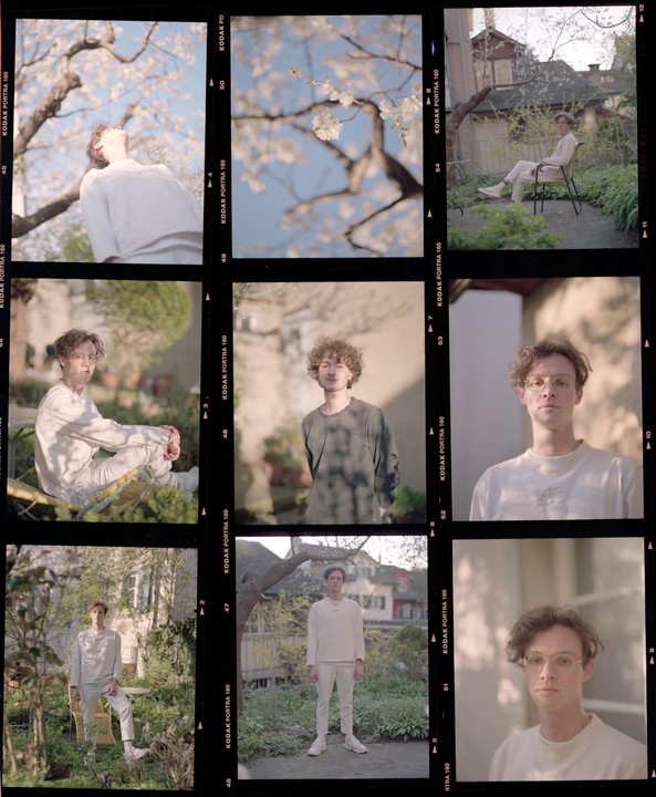 A man is shown in multiple poses and close-ups in a garden with some cherry blossoms.