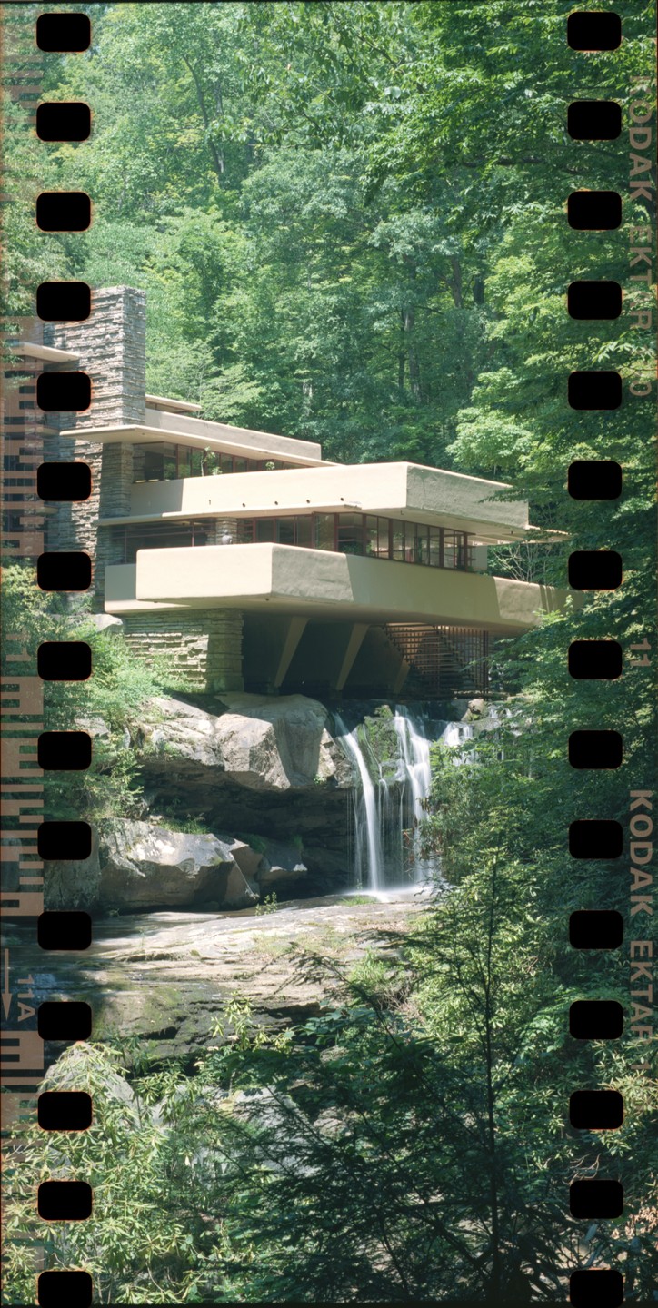 Fallingwater, a house built over a waterfall, is surrounded by trees.