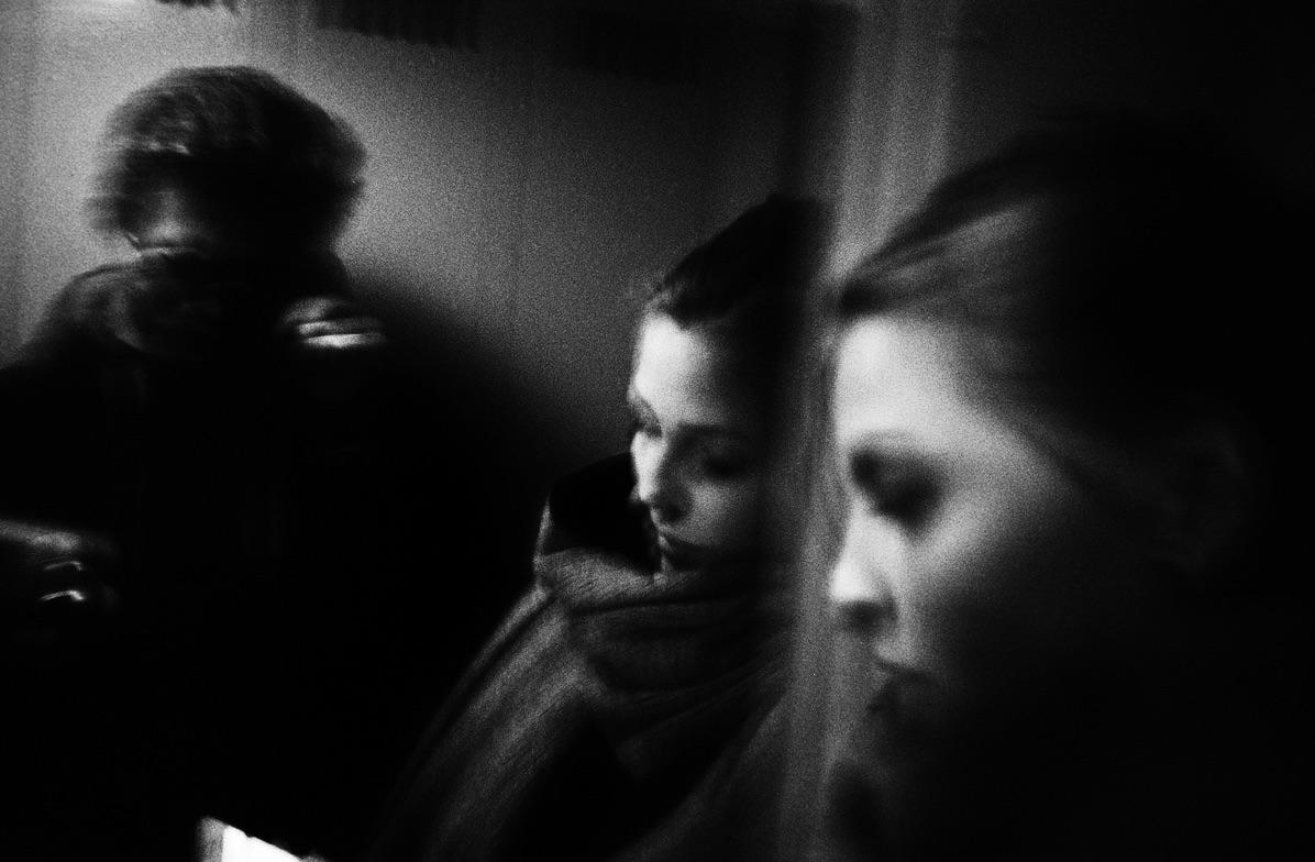 Three women are visible in a dark, grainy, black and white image.