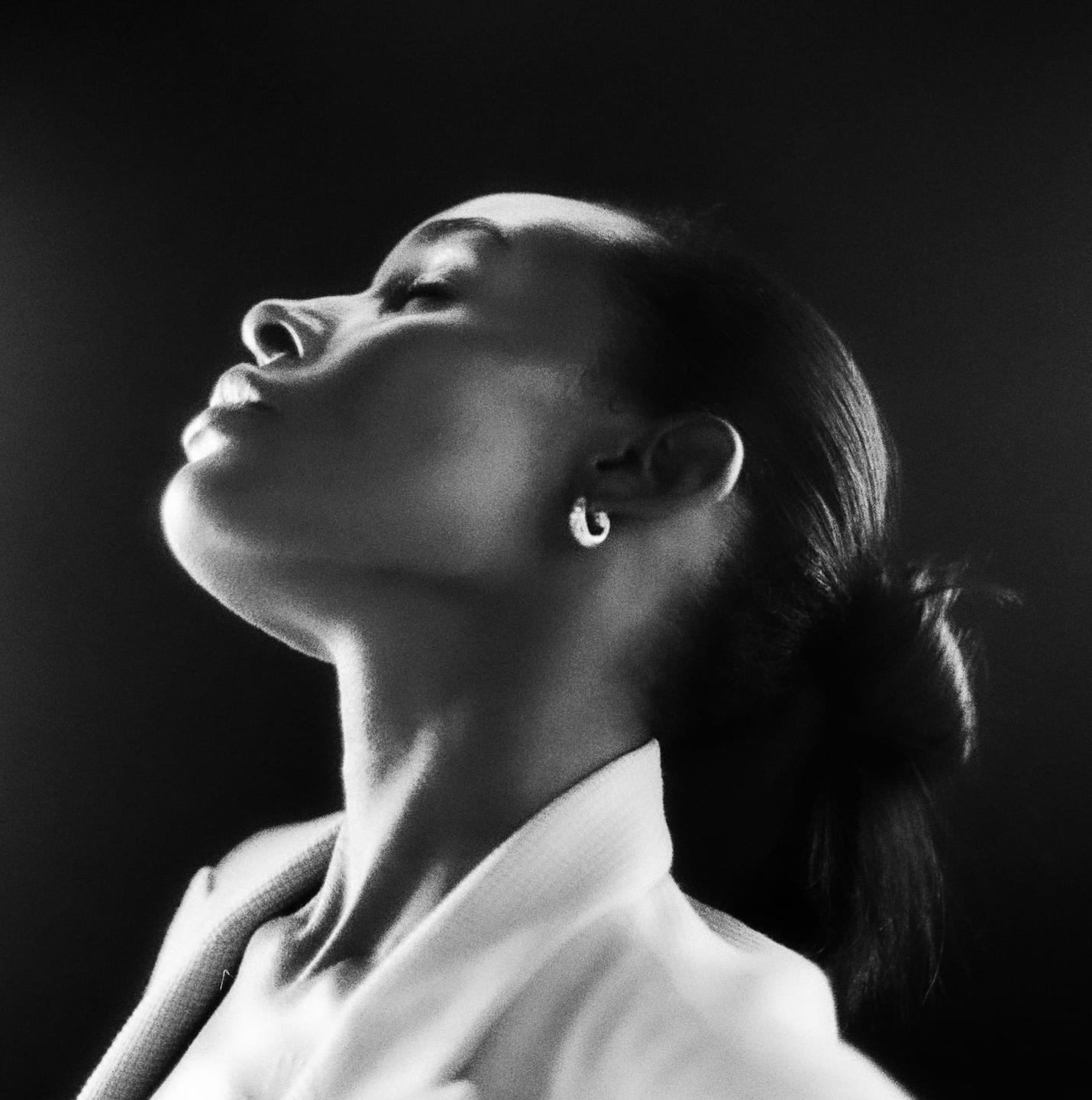 A woman with her head tilted back and eyes closed is illuminated by light from above.