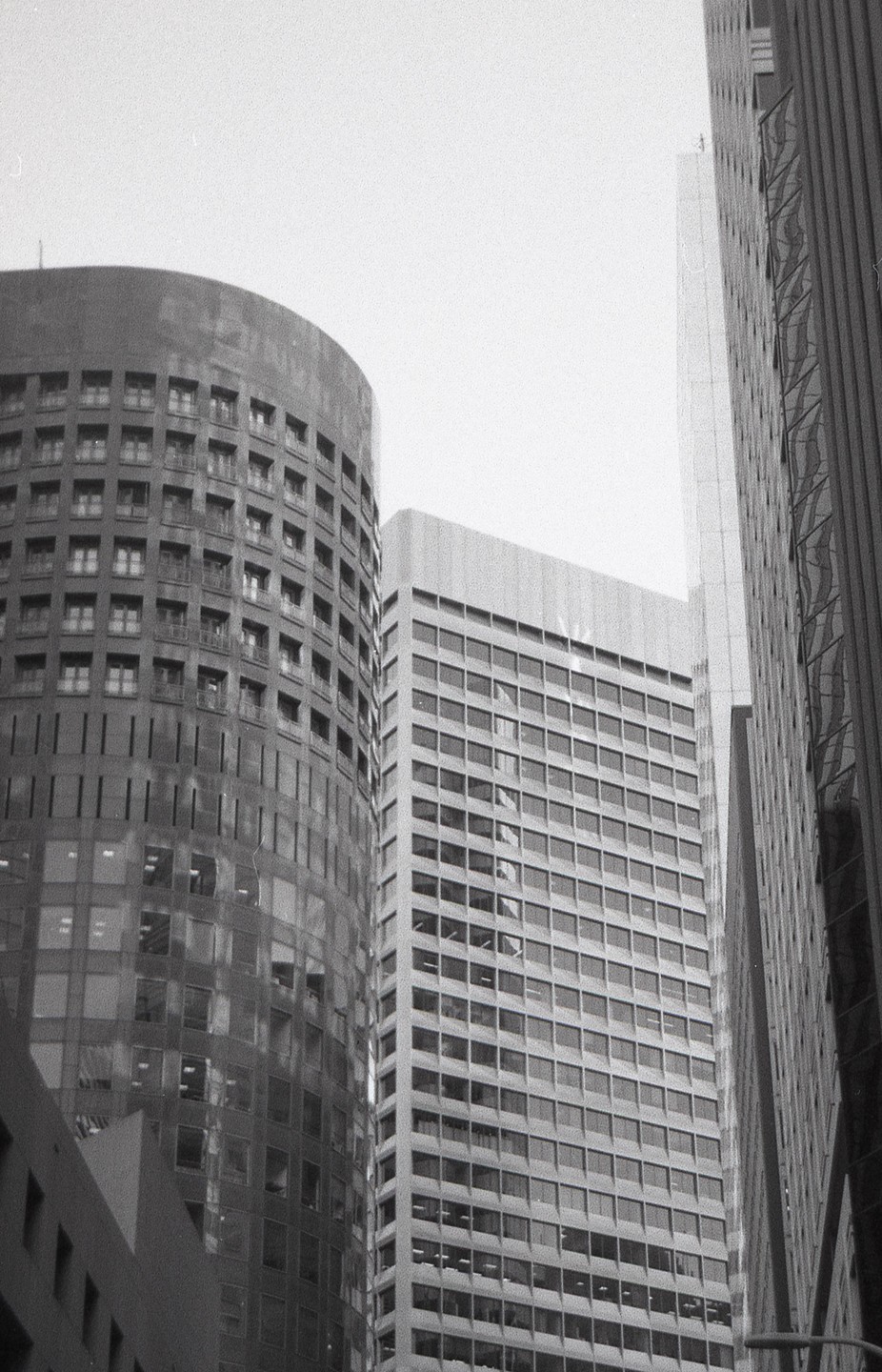 Three tall buildings with many windows are visible from a low angle.