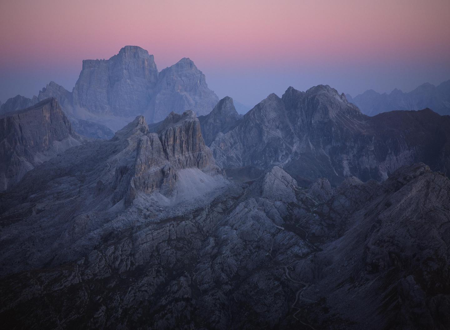 A mountain range is visible under a twilight sky with a pink and purple gradient.