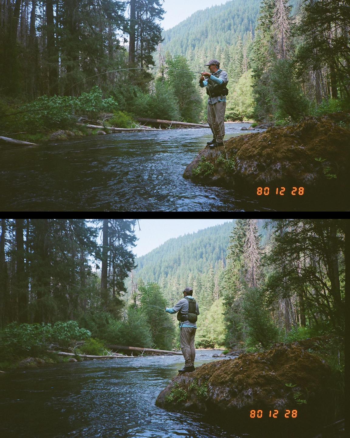 A man stands on a mossy rock in a river, fly fishing with a forest and mountain in the background.