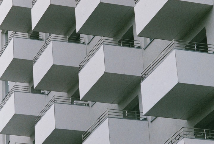A repeating pattern of balconies with railings is visible on the side of a building.