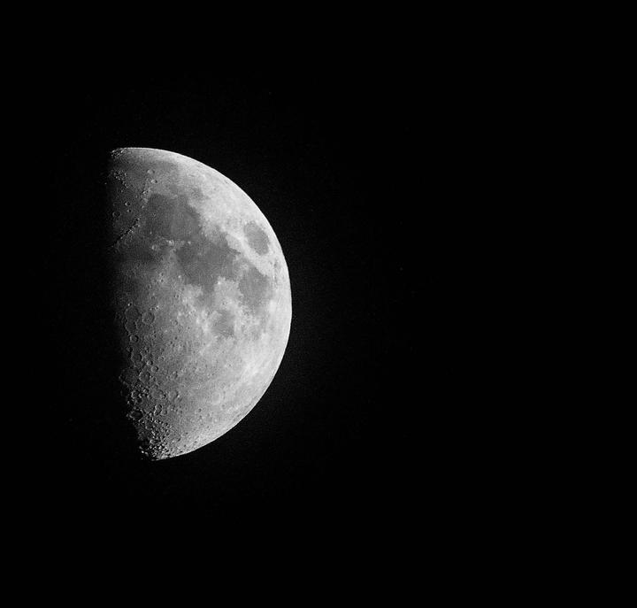 The moon is visible in the night sky, showing its craters and texture.