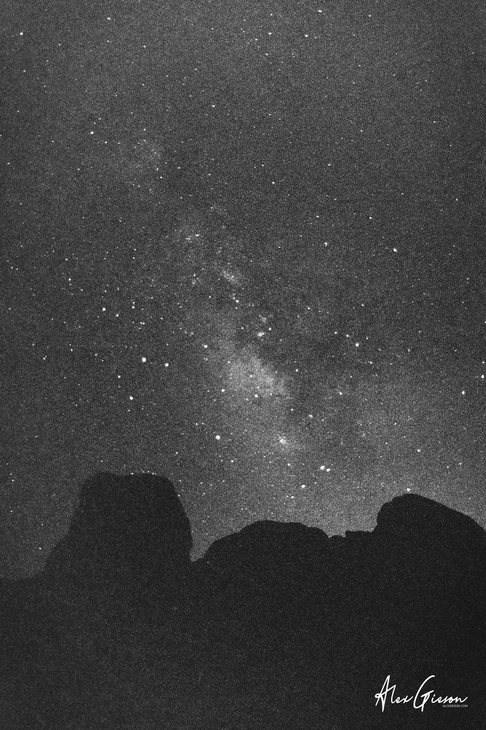 The milky way is visible above a dark mountain range.