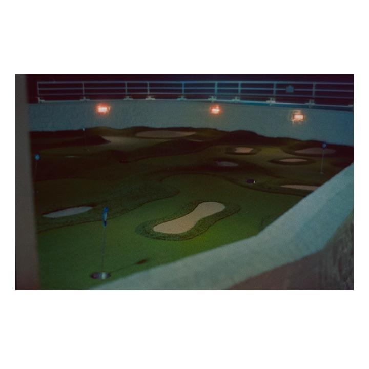 A miniature golf course is illuminated at night on a cruise ship.