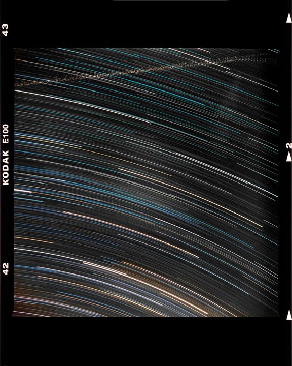 Long exposure photography captures star trails across the night sky.
