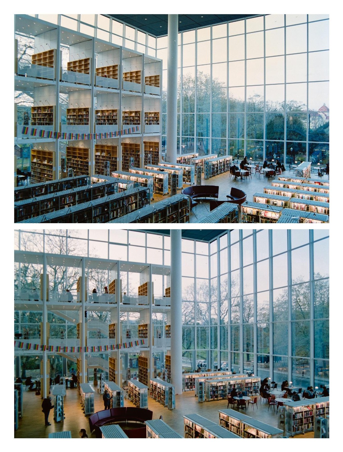 A large, modern library with tall windows and multiple levels of bookshelves is filled with people reading and studying.