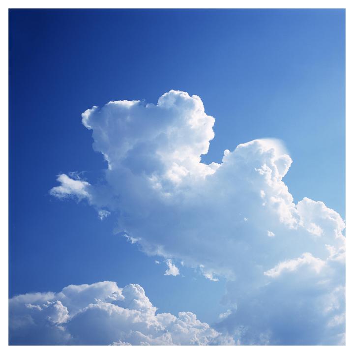 A large cloud formation is visible against a bright blue sky.