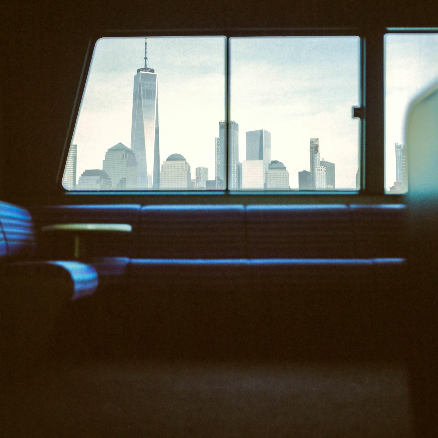 A view of the New York City skyline with the Freedom Tower from inside a ferry.