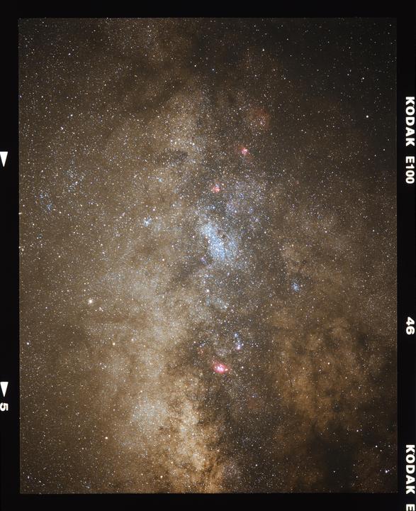The milky way core is visible in a night sky filled with stars and nebulae.