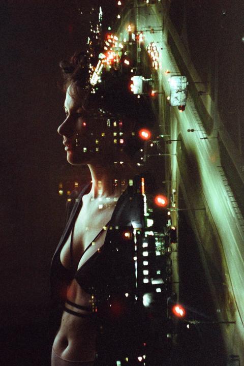 A woman's profile is superimposed over a night cityscape with a highway.