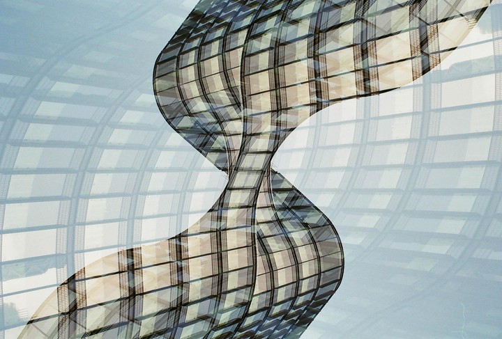 A double exposure shows a curved, gridded structure against a lighter, gridded background.