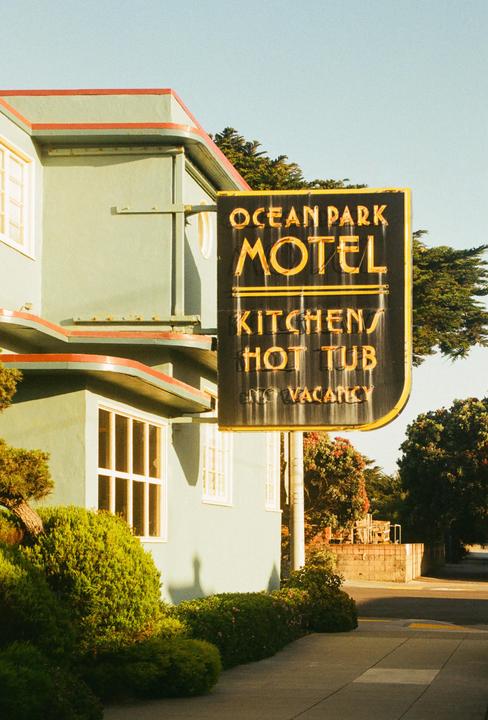 A vintage motel sign for Ocean Park Motel is visible next to a light green building with red trim.