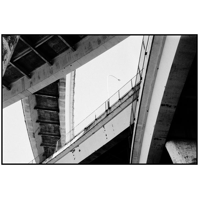 A street light is visible between concrete overpasses.