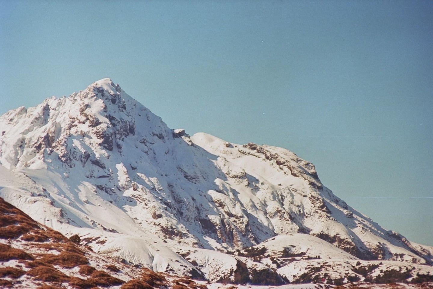 A snow-covered mountain range is visible under a clear sky.