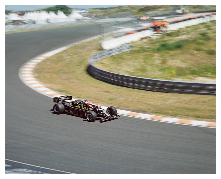A race car is speeding around a track with blurred surroundings.