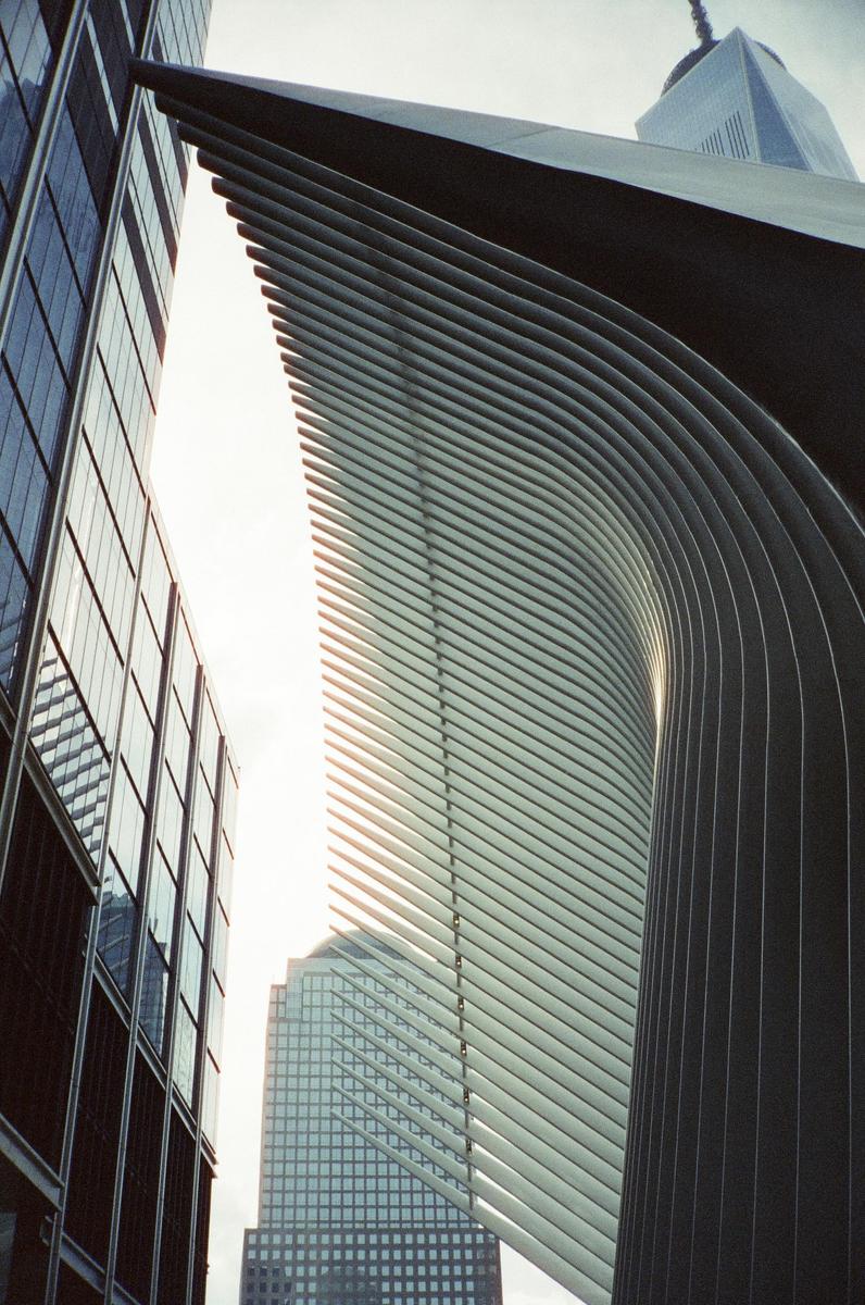 A low-angle view shows the Oculus building and other skyscrapers in New York.