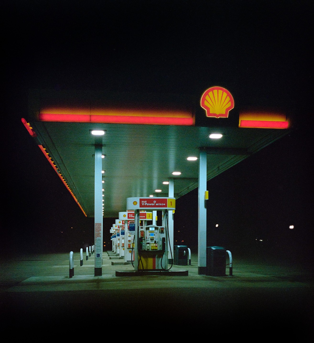 A Shell gas station is illuminated at night.