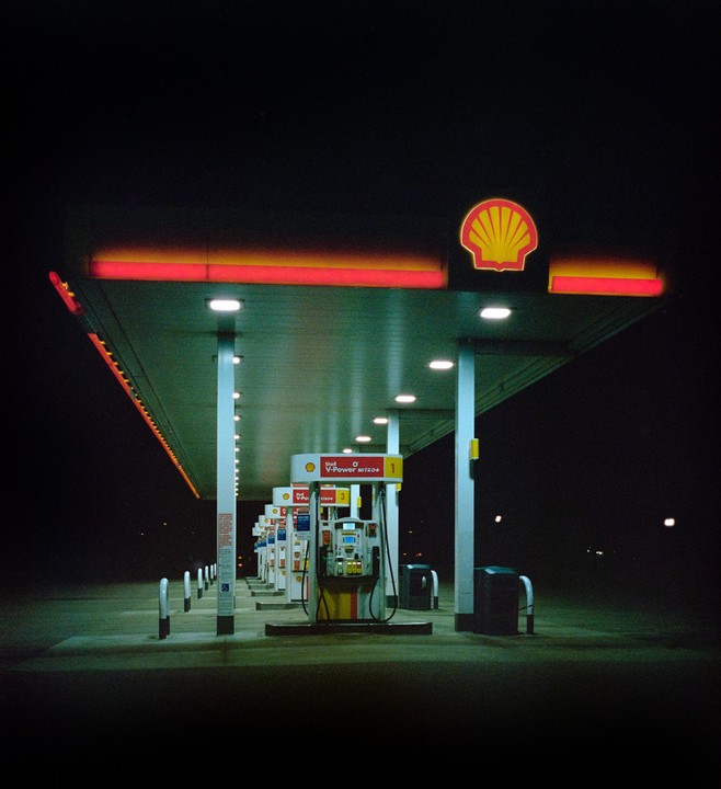 A Shell gas station is illuminated at night.