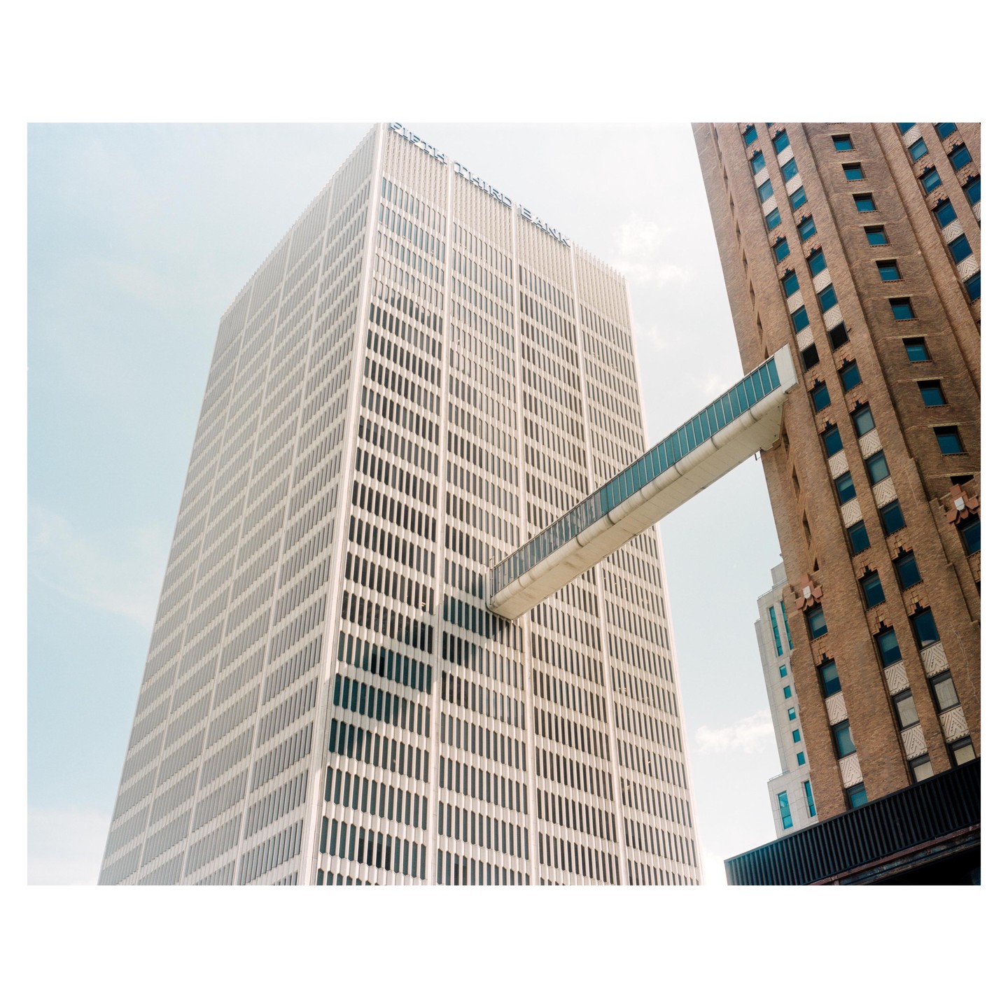 Two tall buildings are connected by a skybridge.