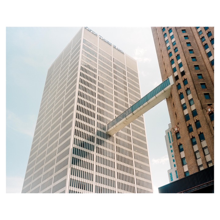 Two tall buildings are connected by a skybridge.