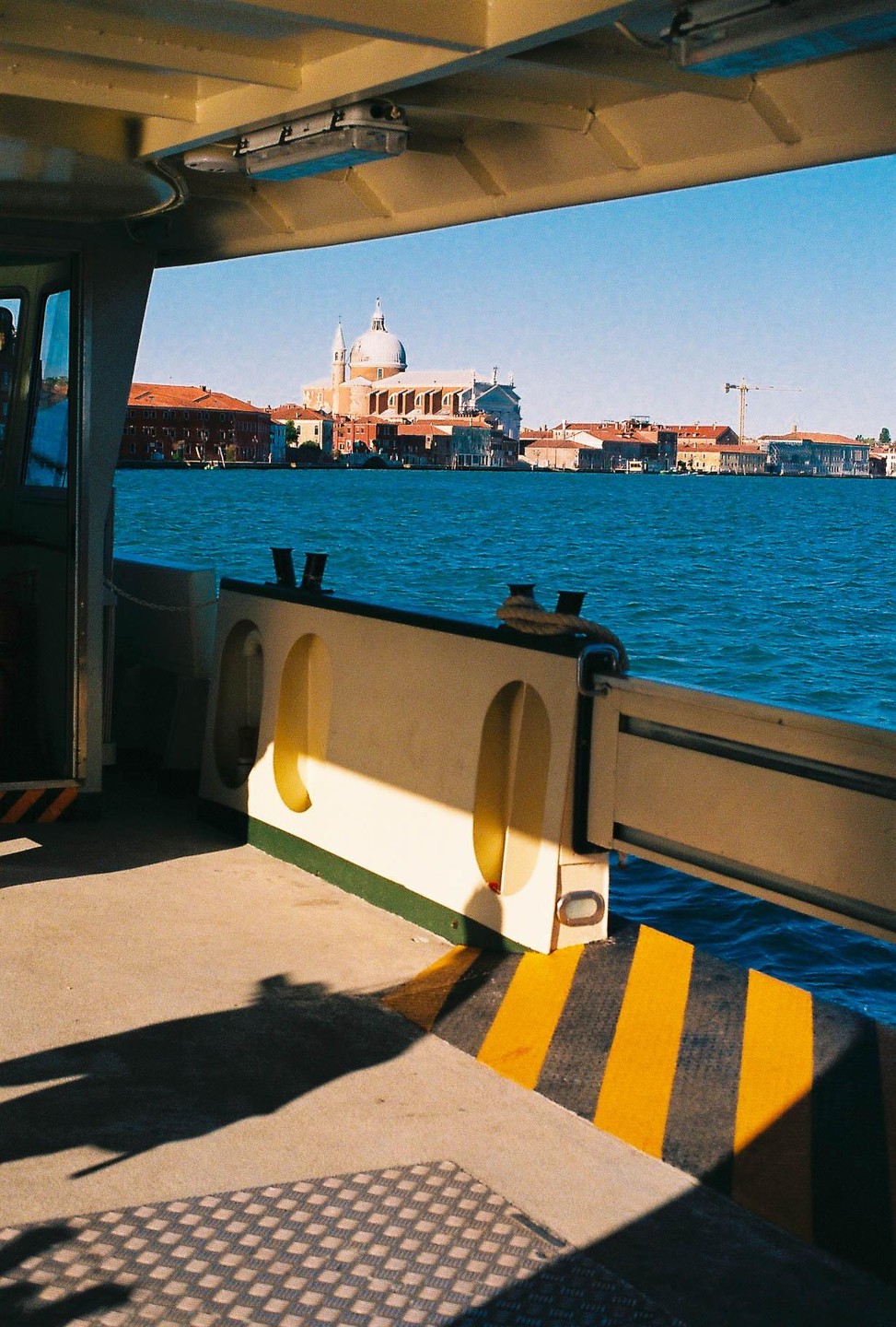 A view of a city with a large domed building across a body of water, seen from inside a boat.