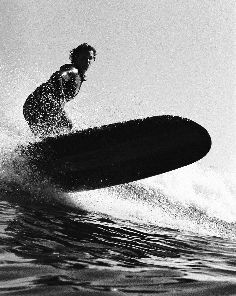 A surfer rides a wave on a surfboard.