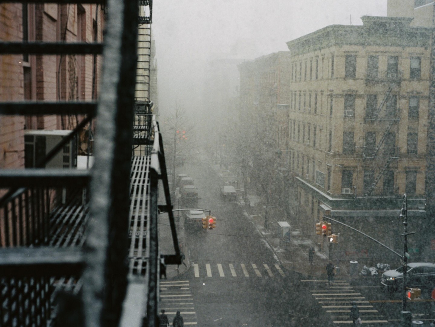 A snowy street scene in Manhattan is viewed from a fire escape.
