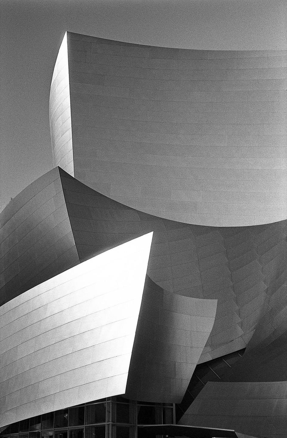 The Walt Disney Concert Hall is shown in black and white, highlighting its curved and angular metallic surfaces.