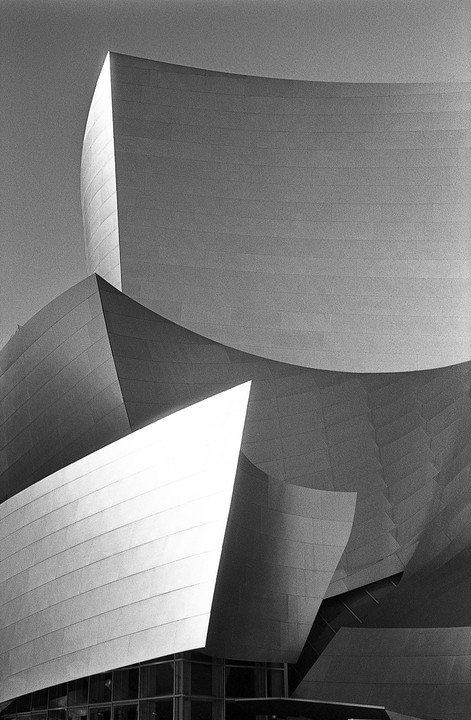 The Walt Disney Concert Hall is shown in black and white, highlighting its curved and angular metallic surfaces.