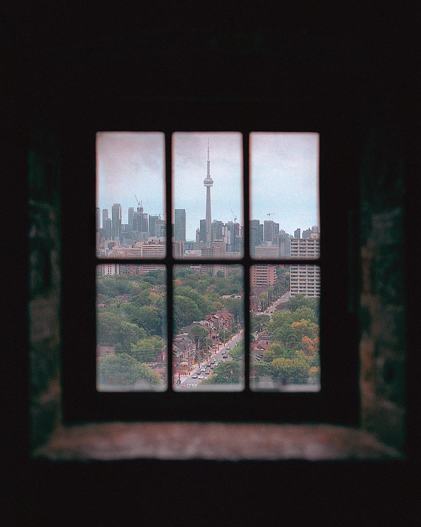 A view of downtown Toronto with the CN Tower is visible through a window.