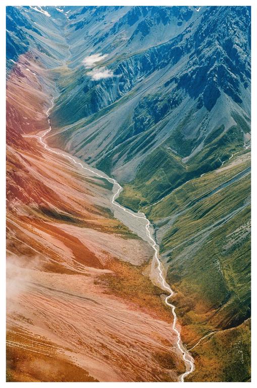 A river meanders through a valley between two mountains.