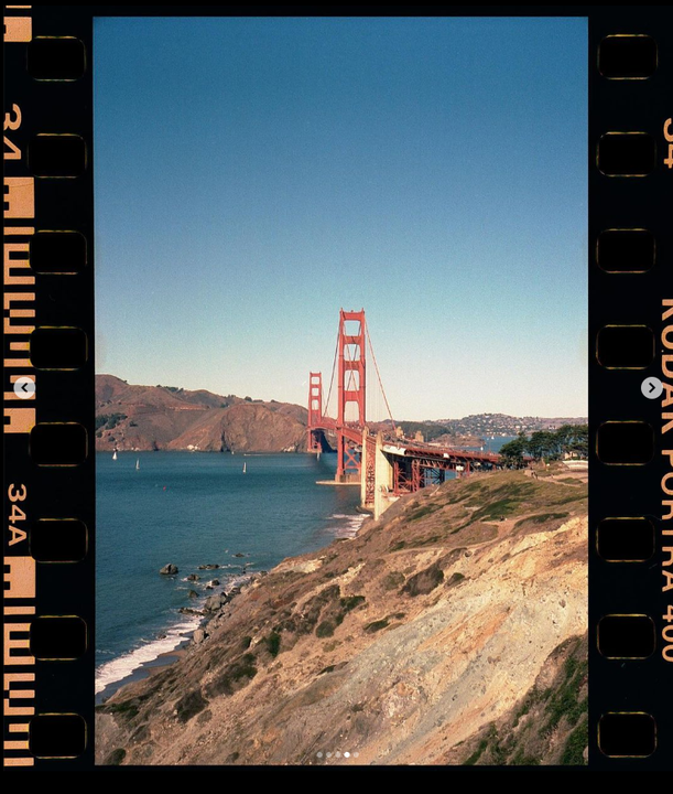 The Golden Gate Bridge spans a body of water with hills and sailboats visible in the background.