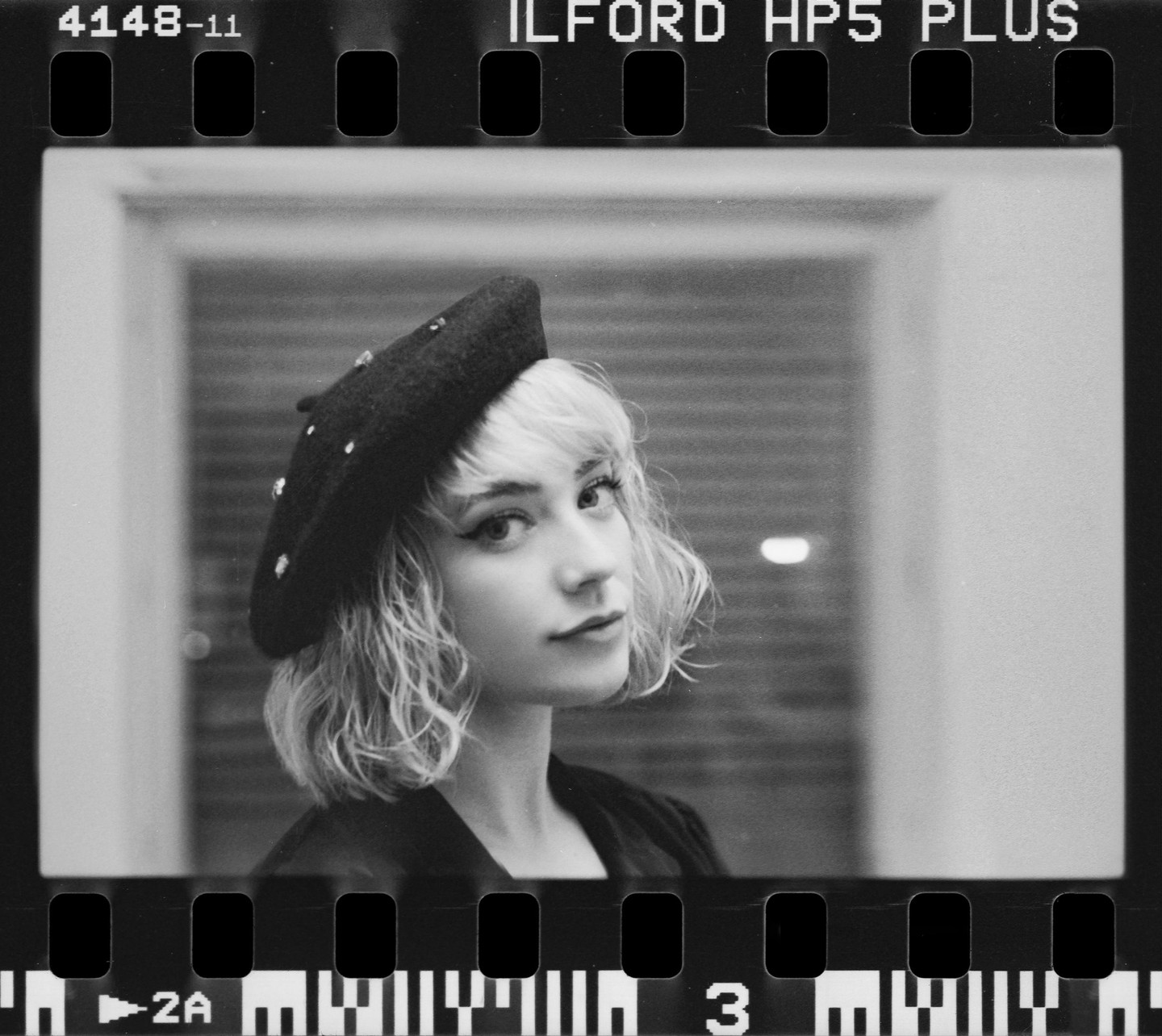 A woman with a beret looks at the viewer.