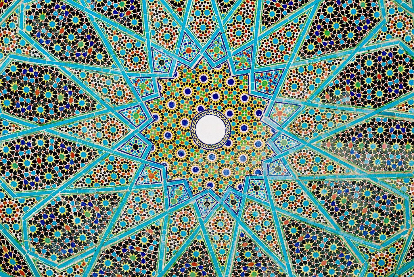 A detailed view of a colorful mosaic pattern with geometric shapes and a central circular motif is shown.