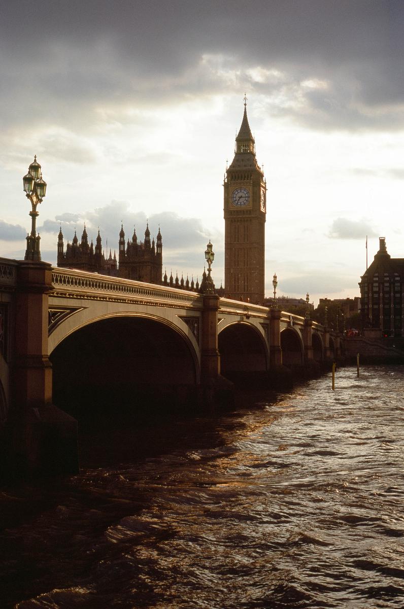 Westminster Bridge and the Elizabeth Tower are visible from the water under a cloudy sky.