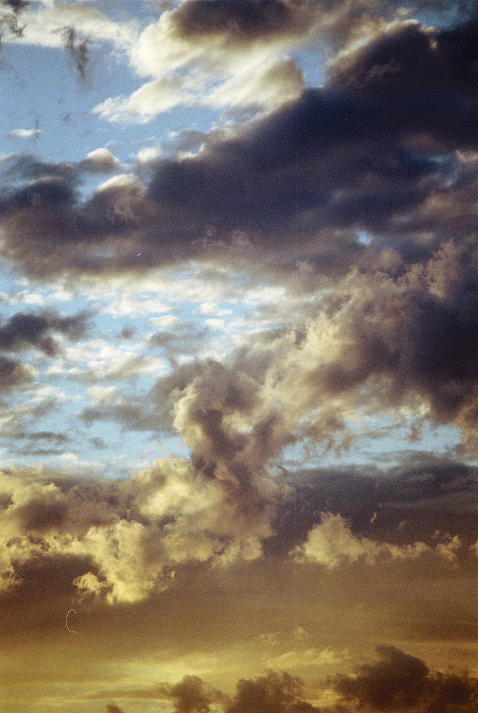 A dramatic sky is filled with dark and light clouds, with hints of blue sky peeking through.
