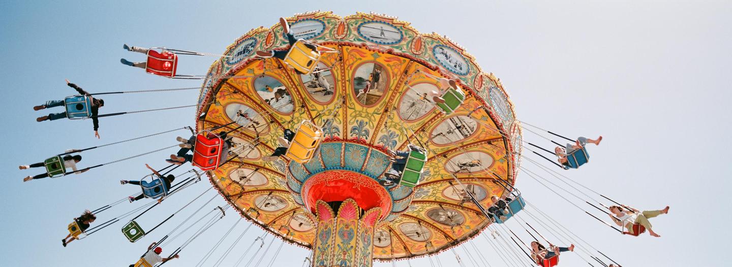 People ride a colorful swing ride at an amusement park.