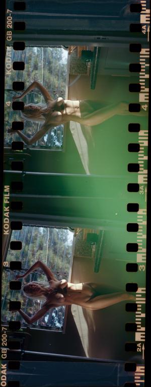 A woman is lying on a surface with light coming from a window.