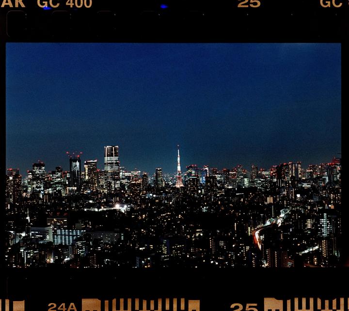 A panoramic view of the Tokyo skyline at night, with the Tokyo Tower visible in the distance.