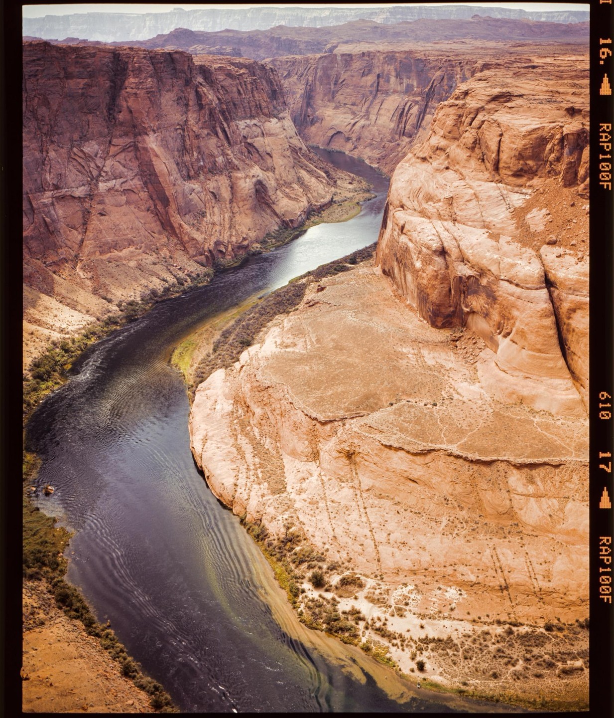 A river winds through a deep canyon with steep, rocky walls.