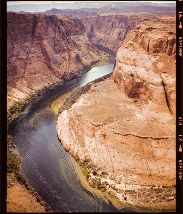 A river winds through a deep canyon with steep, rocky walls.