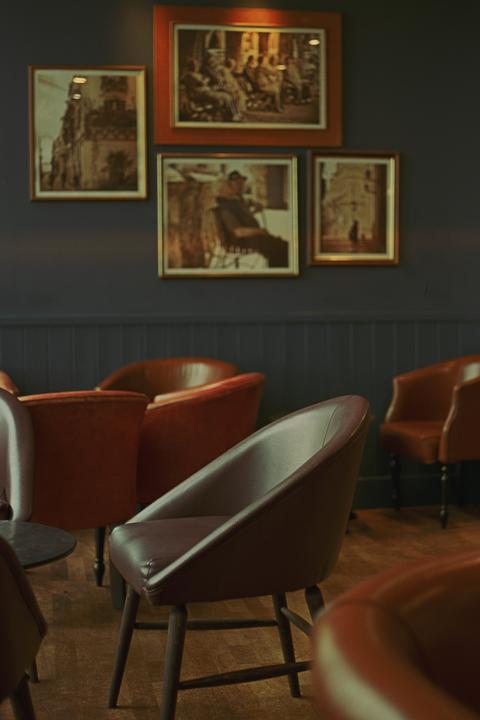 A room with several chairs and framed pictures on the wall is visible.