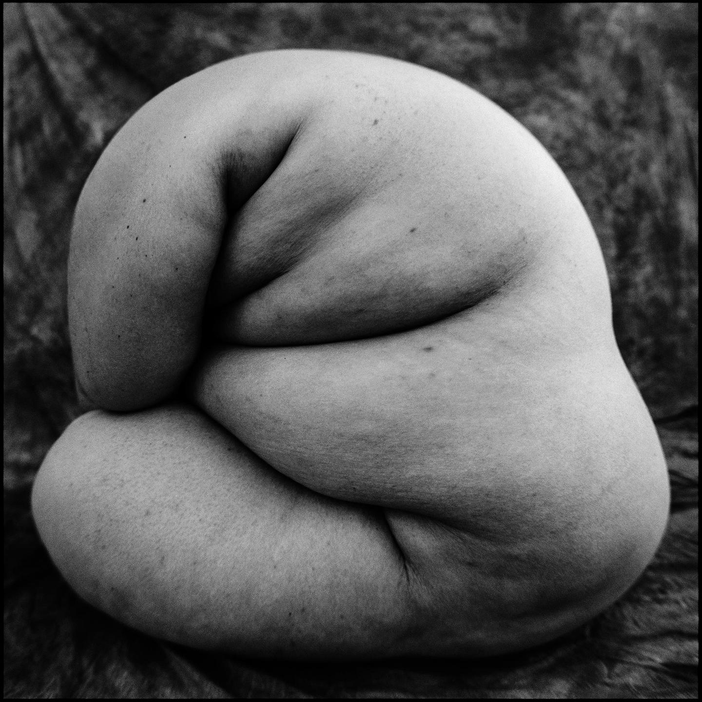 A person's body is curled up, creating a monolith-like shape.