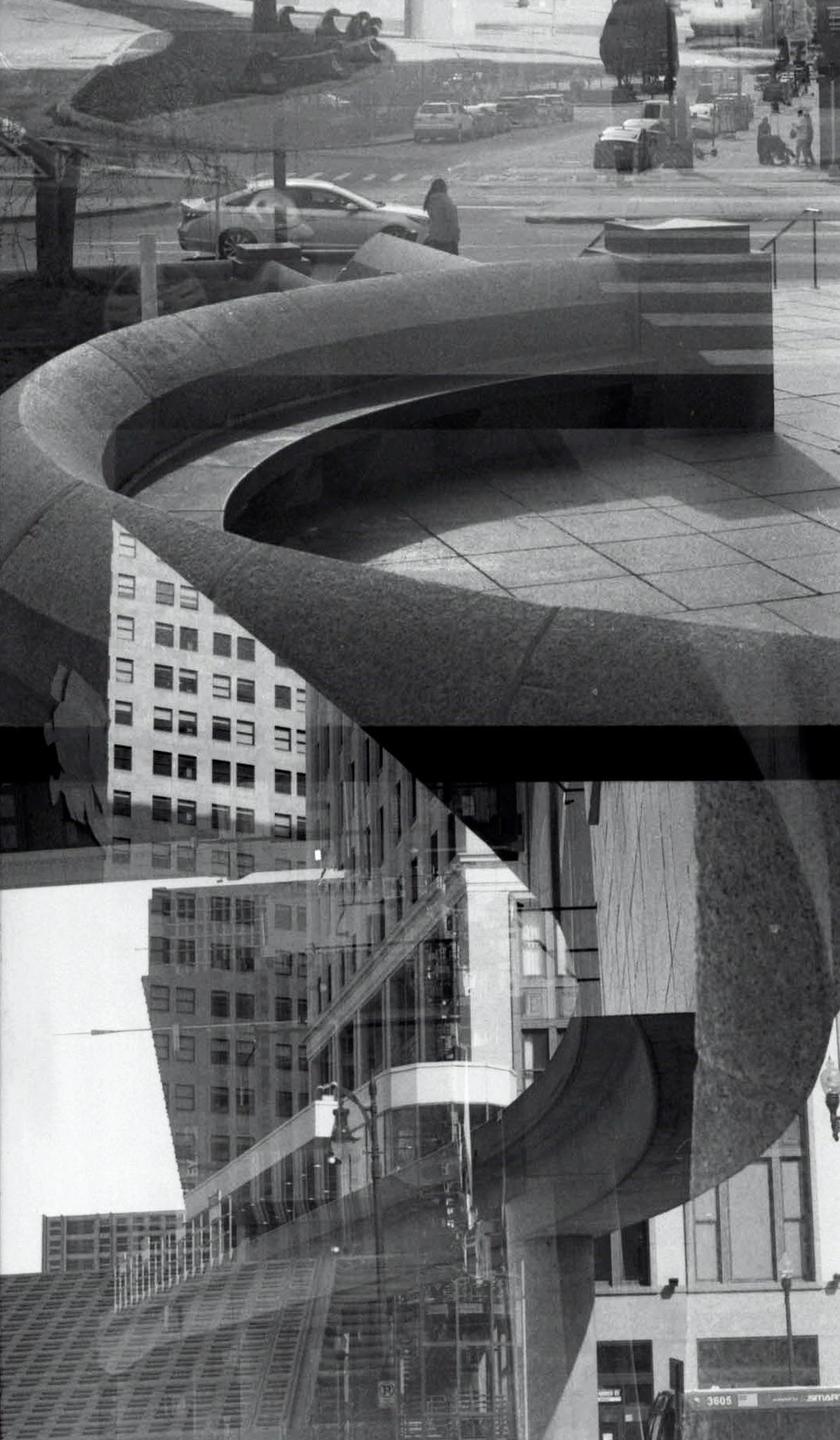 A double exposure shows a street with cars and a person, a curved concrete structure, and multiple buildings.